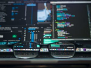 Glasses in front of a computer showing big data